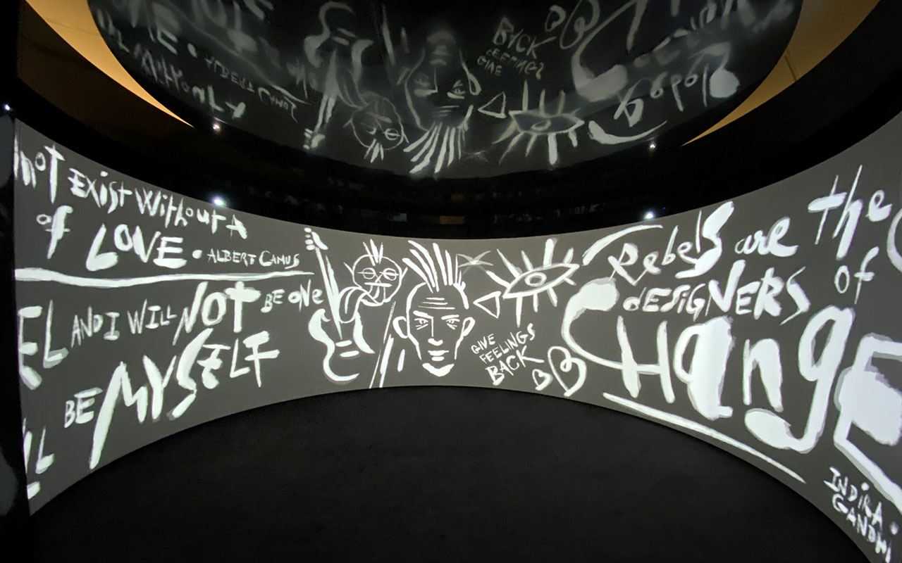 Runder Raum, dessen gekrümmte Wand und Decke mit handgezeichneten Zitaten bespielt werden