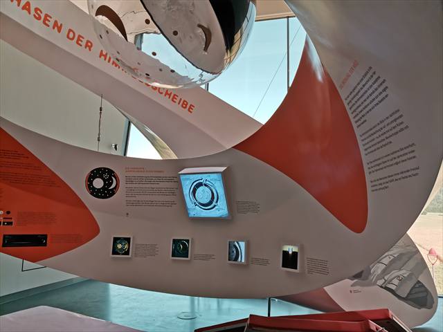 Geschwungene Ausstellungsarchitektur mit Monitoren und Grafiken zur Himmelsscheibe