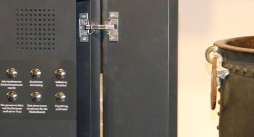 Hörstation mit Lautsprecher und sechs Auswahltasten neben einem Ausstellungsobjekt