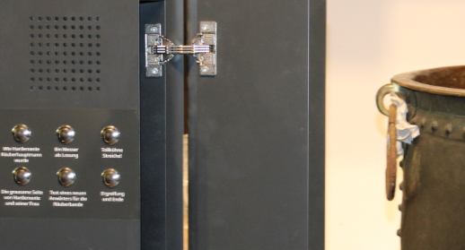 Hörstation mit Lautsprecher und sechs Auswahltasten neben einem Ausstellungsobjekt