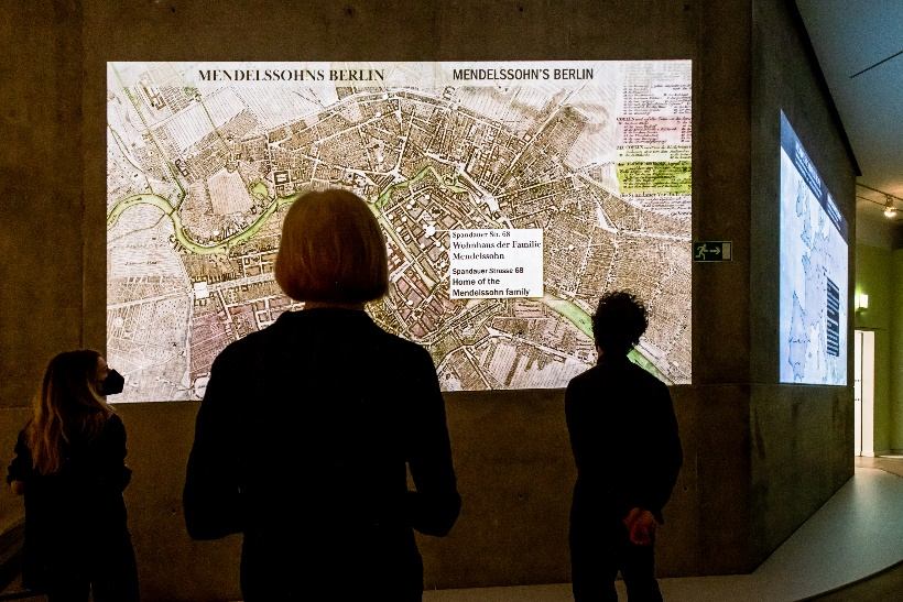 Besucher vor einer großflächigen Projektion des historischen Stadtplans „Mendelssohns Berlin“