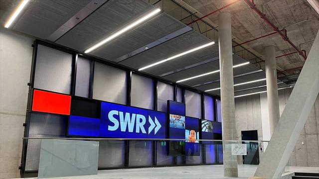 Foyer mit großer Displaywand und SWR-Schriftzug hinter einer Glasbrüstung