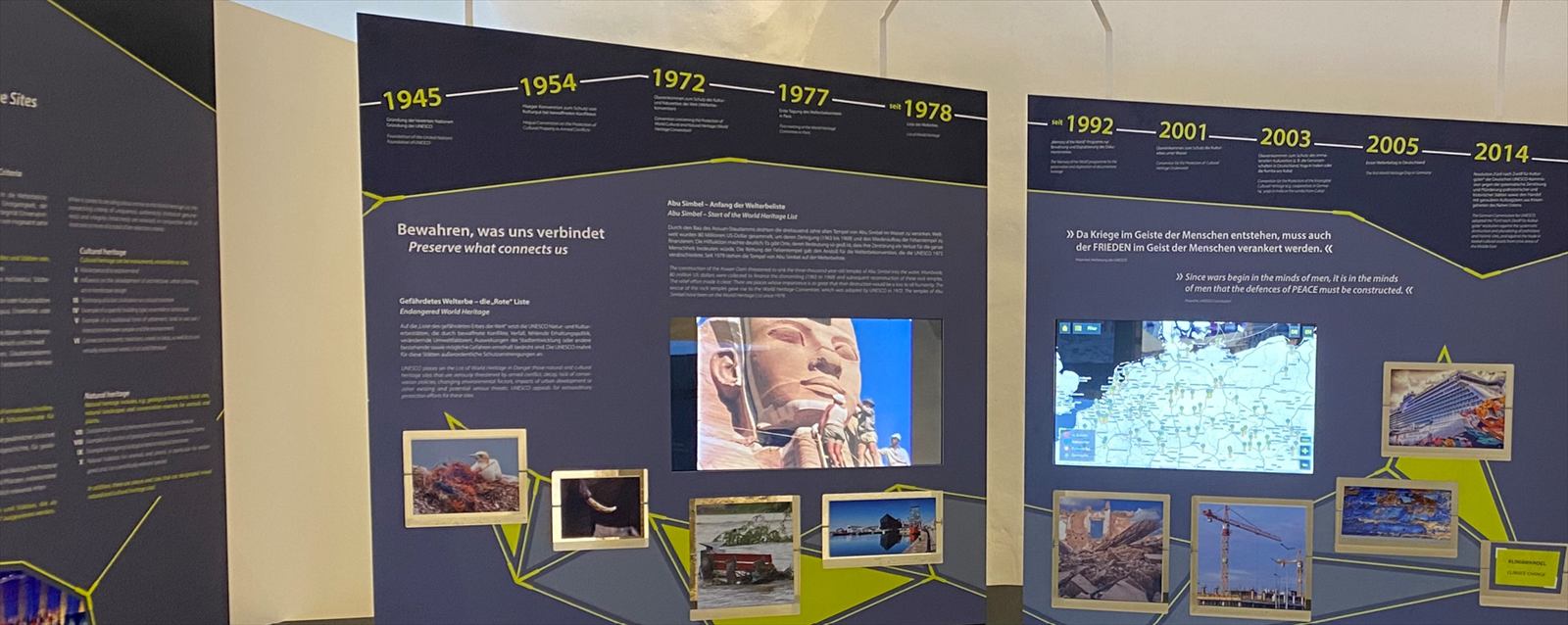 Ausstellungswand mit Zeitleiste von 1945 bis 2014 und integrierten Bildschirmen