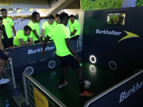 Spieler im neongelben Trainingsshirt schießt im Tiki-Taka-Tempel auf leuchtende Ringziele